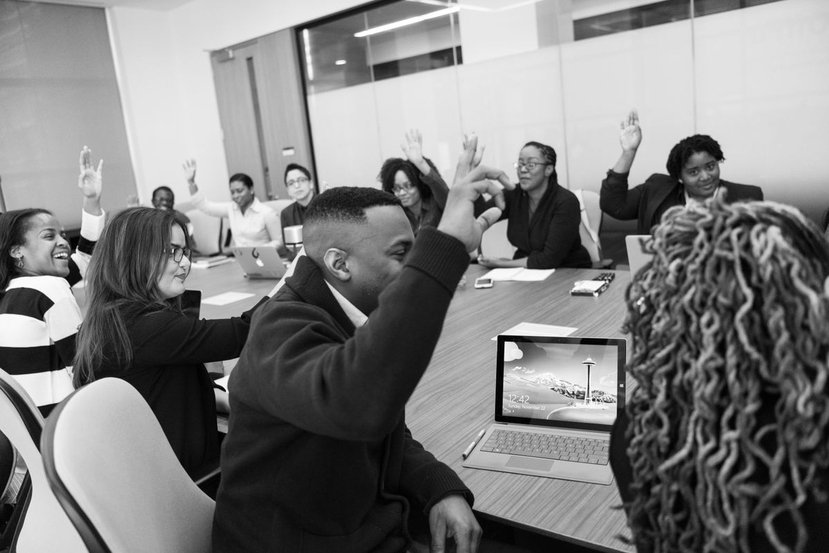 Members of an association raising hands to vote during a meeting